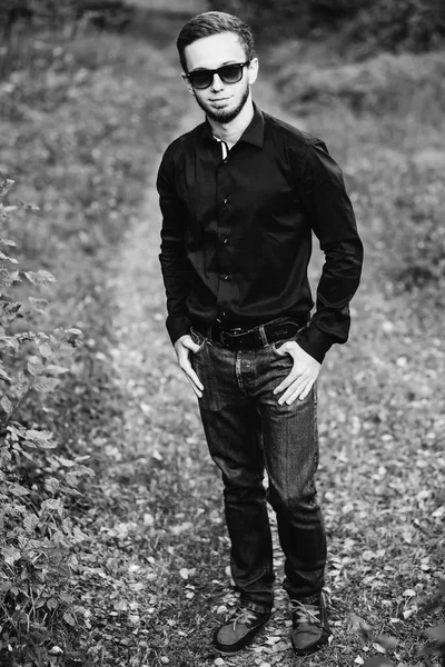 Joven hombre elegante con camisa negra cogido de la mano en los bolsillos — Foto de Stock