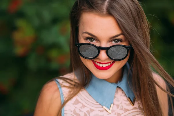 Beautiful girl lowering her sunglasses and looking happy at came — Stock Photo, Image