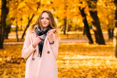 Genç ve güzel bir bayan ceket ve boyun atkısı turuncu sonbahar zemin üzerine sıcak portresi