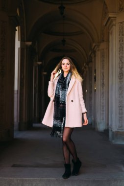 Eski kemer duran güzel genç kadın açık bir palto giyer