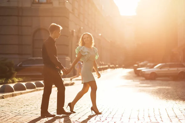 Glückliches junges Paar spaziert gemeinsam durch die Stadt und hält — Stockfoto