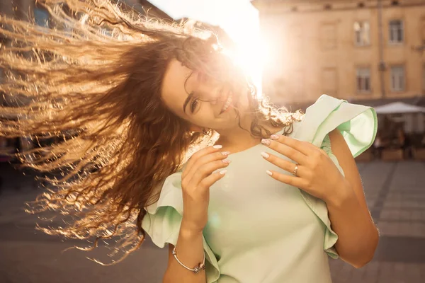 Mooi meisje gooien haar haren met happy glimlach bij zonsondergang. — Stockfoto