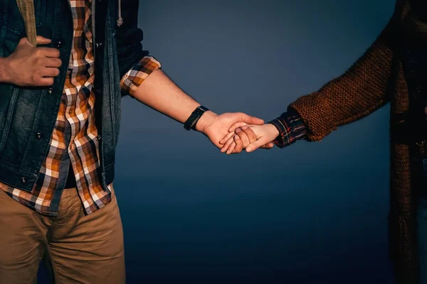 Old-fashioned couple standing together and holding hands close-u