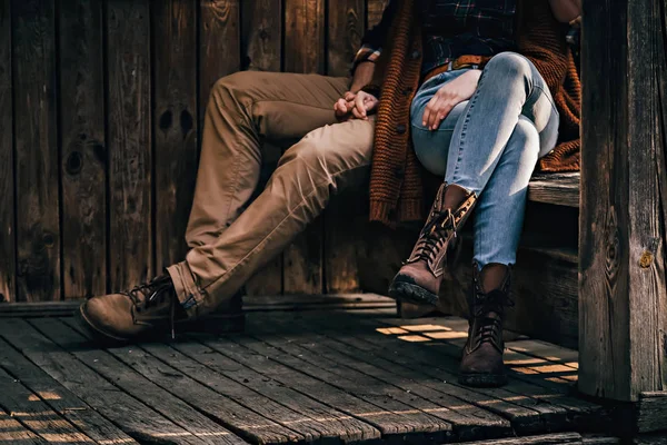 Legs of the stylish vintage looking couple sitting on the bench — Stock Photo, Image