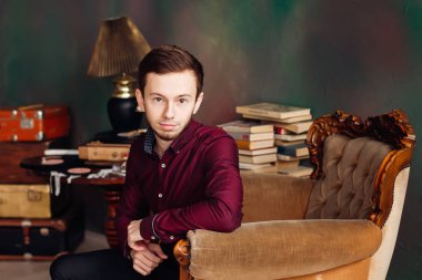 Zarif adam oturmuş ve kameraya bakıyor. Moda bakmak