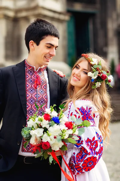 Glückliches Paar in traditioneller Kleidung blickt fröhlich in die Kamera — Stockfoto