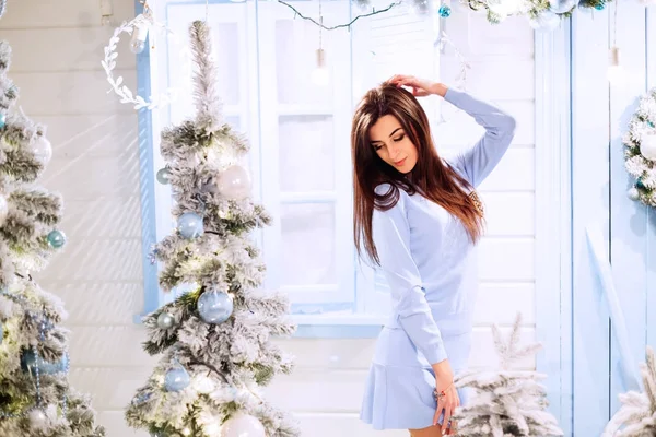 Una giovane donna si erge sullo sfondo delle decorazioni di Capodanno — Foto Stock