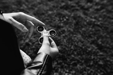 Bir kız, siyah ve beyaz elinde oyuncak spinner iplik