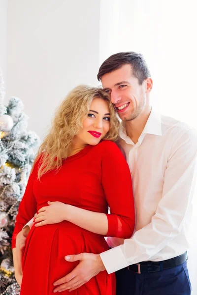 Szczęśliwy człowiek przytula żonę w ciąży na tle Chris — Zdjęcie stockowe