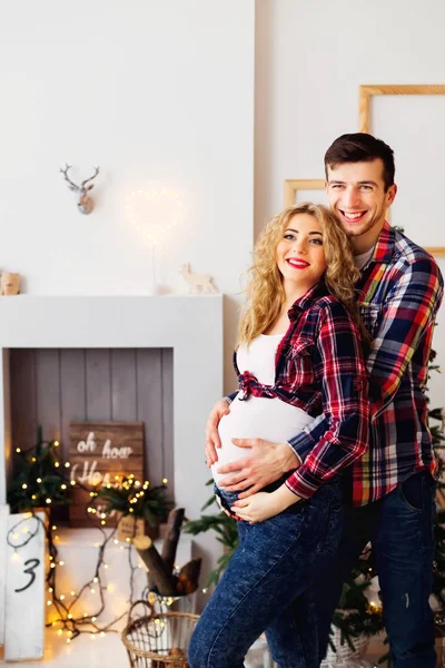 Bir koca şömine ve yeni siz hamile karısını kucaklar — Stok fotoğraf