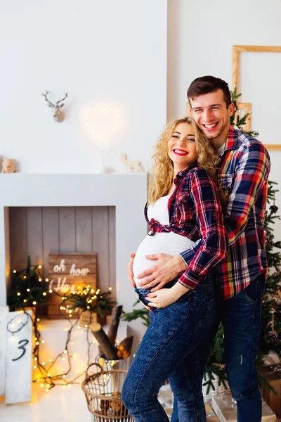 Sonriendo mujer embarazada es feliz en los abrazos de su marido cerca — Foto de Stock