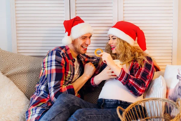 Un couple heureux assis confortablement sur le canapé et mangeant beige — Photo