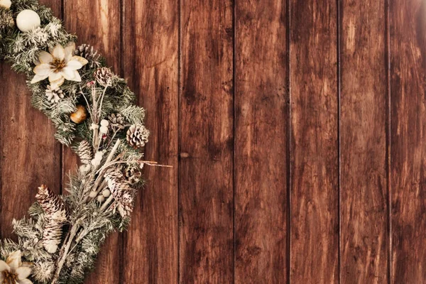 Красивый зеленый рождественский венок с белыми цветами висит на дереве — стоковое фото