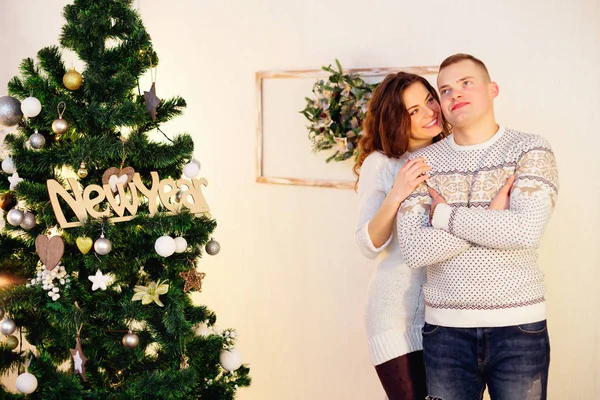 Abraçando o casal macio sorrindo perto da árvore de Natal em viver ro — Fotografia de Stock