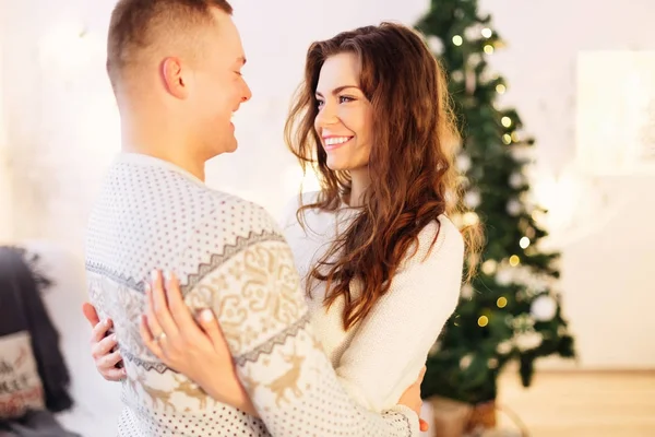 Hermosa pareja joven está celebrando el año nuevo en casa contra un — Foto de Stock