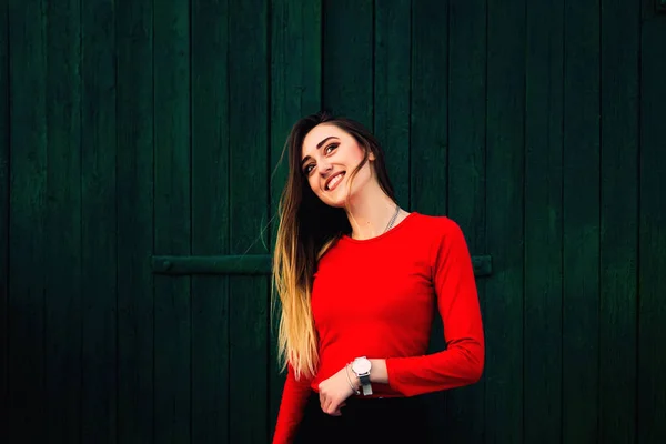 Positieve emoties meisje op de achtergrond van een groen houten muur — Stockfoto
