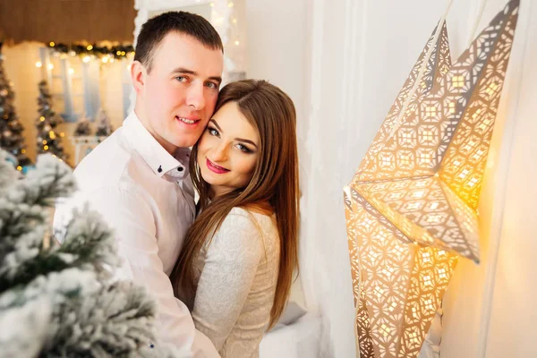 O menino abraça sua namorada em um quarto decorado com att festivo — Fotografia de Stock