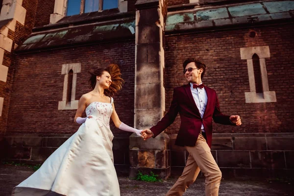 Feliz joven pareja corriendo por la calle en el fondo de —  Fotos de Stock