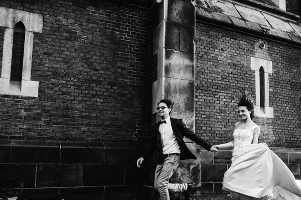 Pareja joven vestida festivamente sobre el fondo de una casa — Foto de Stock