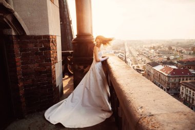 Şık beyaz giysili bir kadın uzun boylu bu balkonda durumda