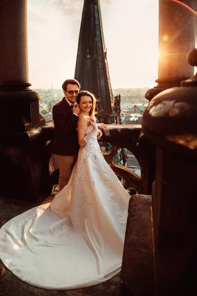 Nygifta står på balkongen i en arkitektonisk master — Stockfoto
