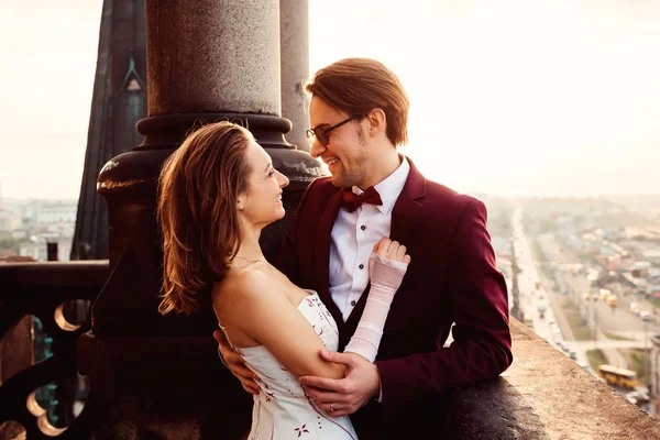 Um marido abraça sua esposa na varanda de um edifício antigo agains — Fotografia de Stock