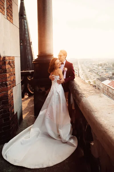 La novia en un vestido elegante está de pie junto a su marido en el —  Fotos de Stock