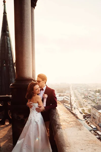 Жених обнимает и нежно целует свою женщину на балконе на — стоковое фото
