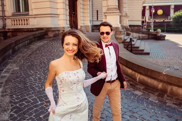 晴れた日に幸せなカップルは、壮大な宮殿を歩く — ストック写真