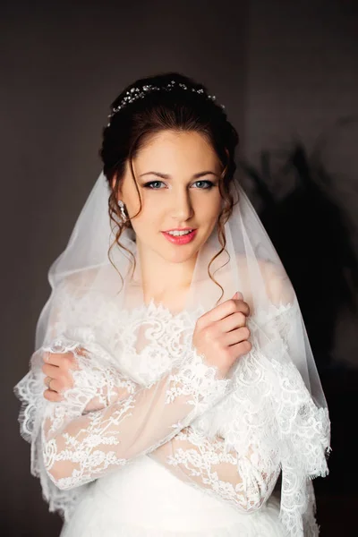 A bela noiva jovem em um vestido branco lindo olha no — Fotografia de Stock