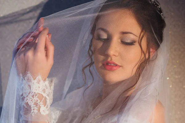 Невеста с белой вуалью имеет красивый макияж и прическа — стоковое фото