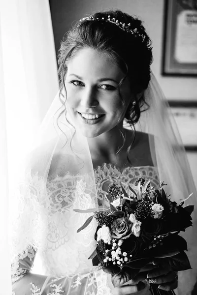 Uma fotografia em preto e branco na qual a noiva sorri e segura — Fotografia de Stock