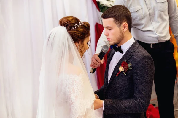 the groom gives an oath to his future wife standing on her knees