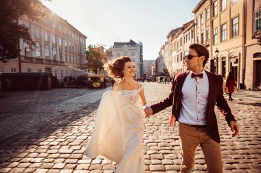 Mutlu bir genç çift güneşli bir günde tarafından sokaklarında yürüyor. 