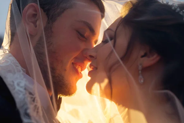 sun rays shine on newlyweds who want to kiss under the wedding v