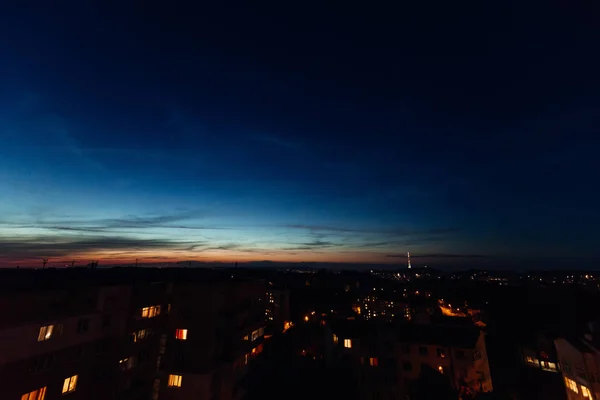 Een stad ondergedompeld in de donkere nacht na zonsondergang en een heldere blu — Stockfoto