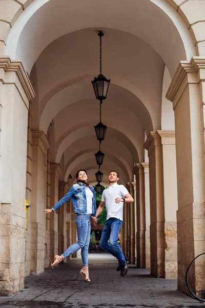 Una pareja enamorada saltando en el fondo del edificio con — Foto de Stock