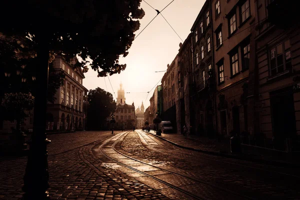 Antigua calle con un pavimento y salida del sol sobre una hermosa ciudad Lvi — Foto de Stock
