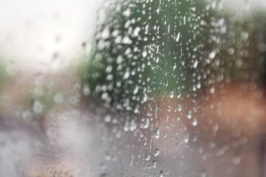 pencere camı üzerinde çeşitli şekillerde yağmur damlaları