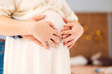 eller erkek ve kadın yuvarlak karnı üzerinde