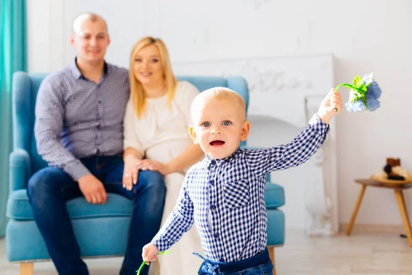 A little boy played with flowers and his parents watch him  and — Stock Photo, Image