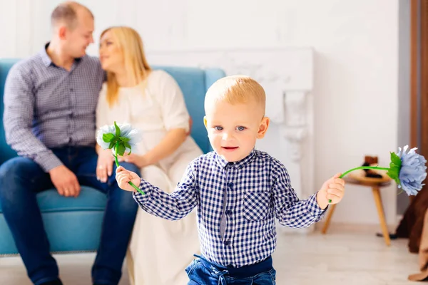 A little boy played with flowers on the background his parents l — Stock Photo, Image