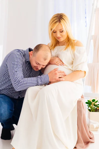 미래 아버지 그의 임신한 아내의 뱃속에 그의 귀를 넣어 — 스톡 사진