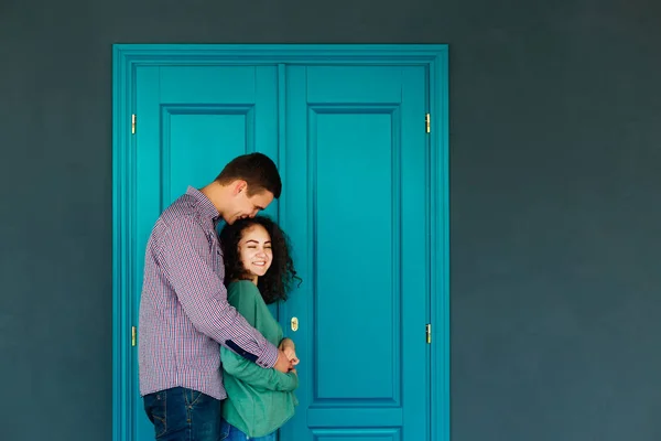 Ευτυχισμένο Ζευγάρι Στην Αγάπη Αγκαλιάζει Φόντο Μπλε Πόρτες Και Τοίχο — Φωτογραφία Αρχείου