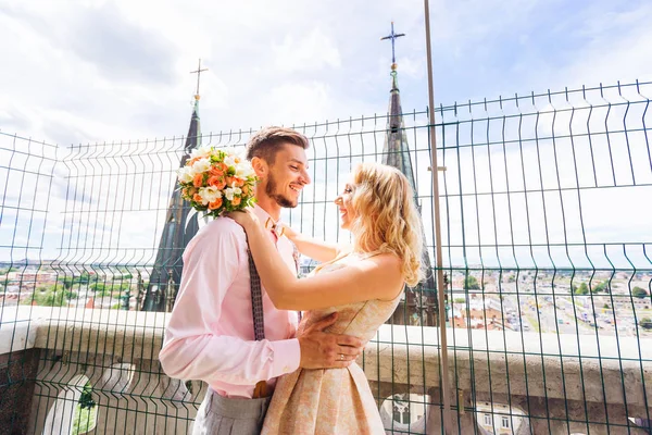 Un novio abraza a su novia que tiene un ramo y que lau —  Fotos de Stock