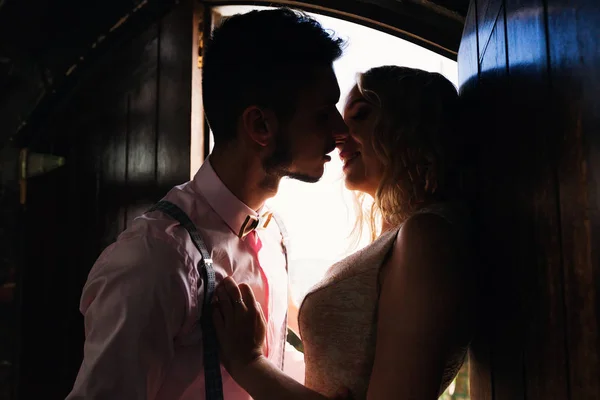 木製のドアの leadi の近くに彼のガール フレンドにキスを望んでいる男 — ストック写真
