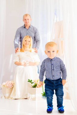 Küçük çocuk ön plan, hamile anne baba ve oğlu backgr üzerinde