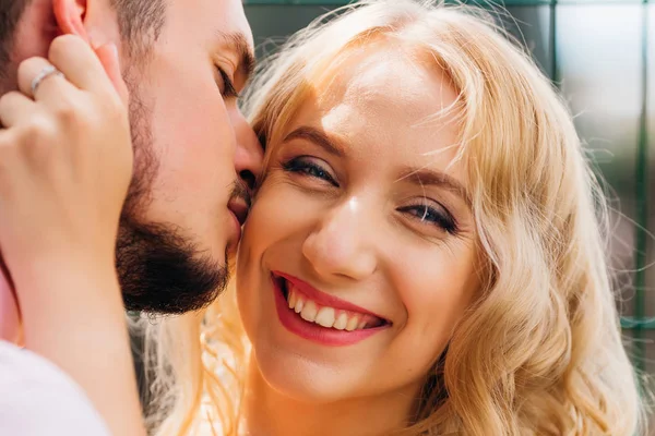 Close-up van een mooi meisje die haar vriendje op een zonnige kussen — Stockfoto
