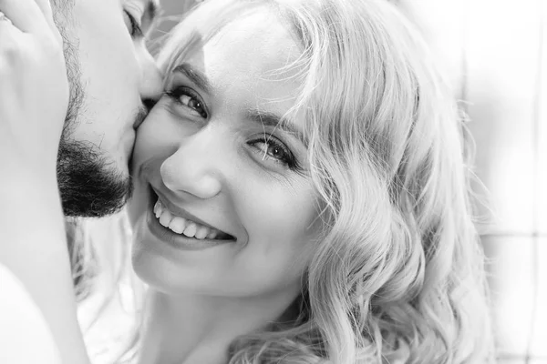 Närbild av en vacker flicka som kysser sin pojkvän på svart en — Stockfoto