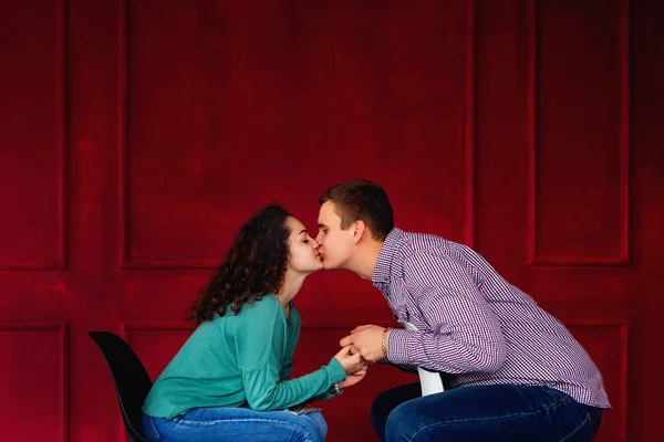 Een paar verliefd zittend op de stoelen en kussen tegen de b — Stockfoto